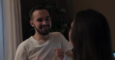 Oturma odasında uzaktan kumandayla dans eden genç çift bir anda kayboldu. Neşeli yüzler üzerinde neşeli müzik ifadeleri hareket ediyor. Video, sevgi dolu bir yakınlık hissi yaratıyor..