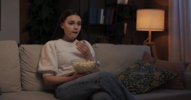 Kadın film meraklısı, oturma odasında oturmuş patlamış mısır yerken heyecan karışımı bir şey oluyor. Sinema korkusunu tamamen içine çekiyor..