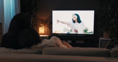 Esmer genç kadınlar, hafta sonları oturma odasında oturup televizyon izleyen lezbiyen çiftin bir haftası vardı. Gerçeklik kavramı. Omzundan vurulmuş..