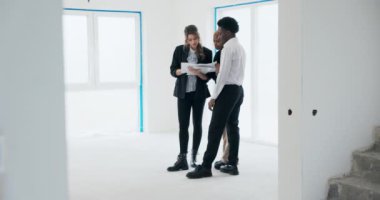 Yenilenmemiş binanın arka planında, sarışın emlakçı idareyi ele geçirir ve alanı Afrikalı Amerikalı çiftlere sunar. Birlikte, odalarda gezinip, tartışıyorlar..