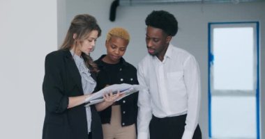 Temsilci, yenilenmemiş binaları çiftlere gösteriyor. Detayları hevesle ve teşvikle tartışıyorlar..