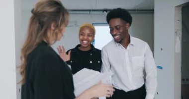 Kontrat ve ev planının sıkıca uygulanmasıyla sarışın emlakçı Afrikalı Amerikalı çiftin gelişini heyecanla bekliyor. İçeri girdiklerinde, dost dalgaları olumlu bir hava yaratıyor..