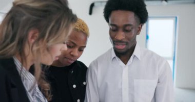 Yoğun bir dikkatle, Afrikalı çift ve emlakçı planların üzerinden yakın plan çekimde geçtiler, olasılıkları ve yeni ev için planlarını tartıştılar..