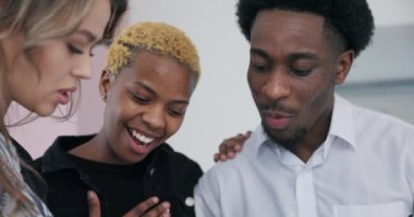 Yakın plan çekimleri Afrikalı çifti ve emlakçıyı derin bir sohbetin içinde yakalıyor, yeni evlerinin detaylı planlarını heyecanla inceliyor..