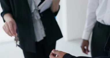 Yakın plan bir emlakçı kadın bu dönüm noktasının Afrika kökenli bir çiftin eline yeni bir evin anahtarını nazikçe veriyor ve çiftlerin gerçek heyecanını ortaya çıkarıyor..