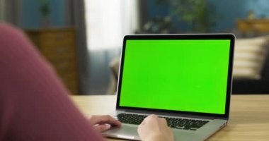 Oyun meraklısı, gezici oyunlar oynayan ya da online çok oyunculu maçları dizüstü bilgisayarda yapan. Heyecanlı yüz ifadeleri ve ara sıra yaptığı jestler onun eğlencesini ve oyun deneyimine dalmasını yansıtıyor..