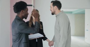 İş Fırsatı çifti Afrikalı emlakçıyla görüşüyor ticari mülkleri araştırıyor yeni iş yeri planlarını tartışıyor, potansiyel müşteri tabanı vizyonla hizalanıyor.