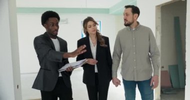 İlk kez ev satın alanların ilgilenen temsilcisi genç bir çifte ilk ev alımlarında yardımcı olur, bilgili ve rahat hissetmelerini sağlar..