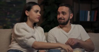 İki yetişkin, oturma odasında oynaşıp patlamış mısır atıyorlar romantik bir komedi çifti izliyorlar. Birlikte eğleniyorlar. Sadece yakın arkadaşlar, ortak sinema aşkı üzerine kaynaşıyorlar..