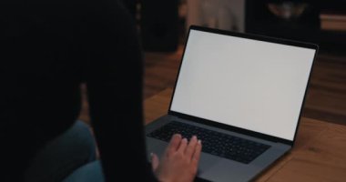 Koyu renk uzun saçlı genç bir kız öğrenci oturma odasında bilgisayarın önünde oturuyor. Beyaz bir ekran görüntüsü çiziyor, çalışıyor..