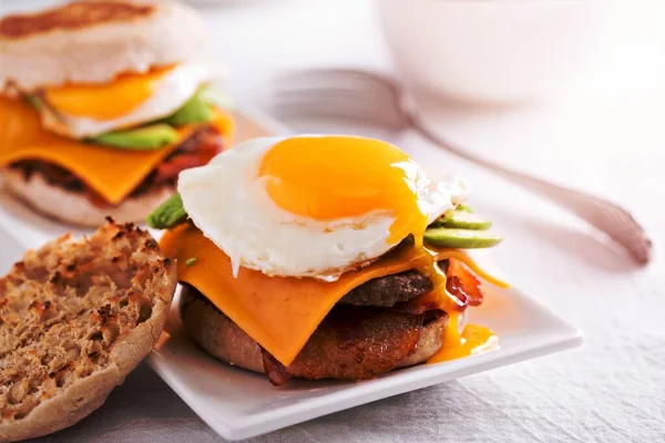 Breakfast burger with fried egg and avocado, cheese and bacon