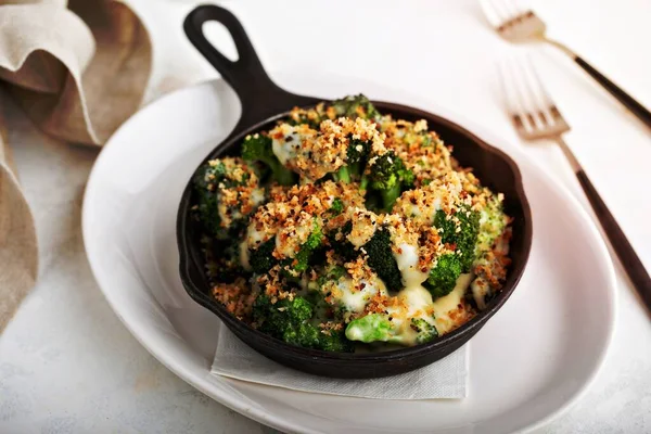 Roasted broccoli crumble in a cast iron pan, healthy side dish