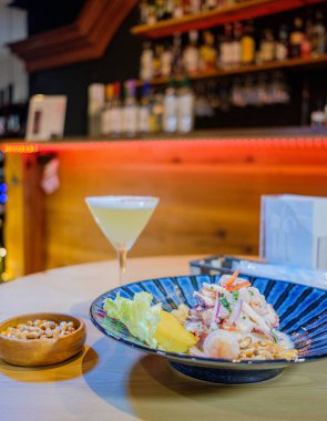 Pisco ve kızarmış mısırla birlikte mavi bir tabakta servis edilen Peru ceviche 'si.