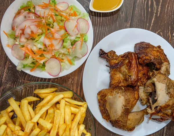 Kızarmış tavuk, patates kızartması, domates, turp ve marul salatası.