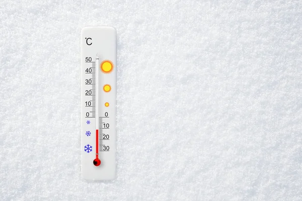 White celsius scale thermometer in snow. Ambient temperature minus 11 degrees celsius