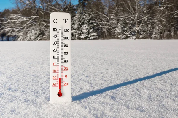 White celsius and fahrenheit scale thermometer in snow. Ambient temperature minus 18 degrees celsius