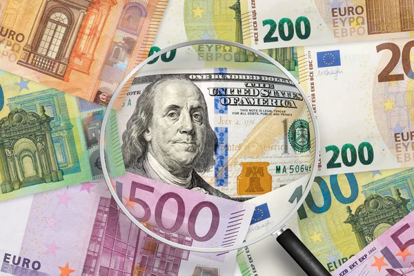 100 dollar and Euros banknotes. EU and USA trade. Euro and dollar rate. View through magnifying glass