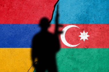 Dağlık Karabağ 'da Ermenistan ve Azerbaycan çatışması. Azerbaycan ve Ermeni bayrağı çatlamış beton duvarda askerle