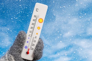 Beyaz santigrat termometresi elinde. Çevre sıcaklığı eksi 29 derece.