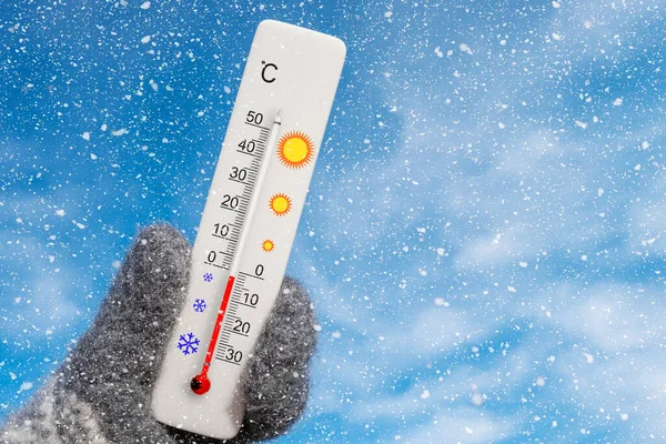 Beyaz santigrat termometresi elinde. Çevre sıcaklığı eksi 2 santigrat derece.
