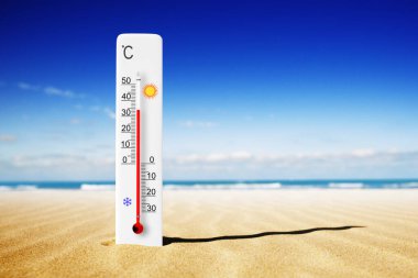 Sıcak yaz günü. Kumda Celsius termometresi var. Çevre sıcaklığı artı 34 derece. 