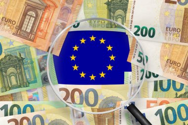 Avrupa Birliği bayraklı banknotlar büyüteçle görülüyor. EUR, Avrupa Birliği 'nin resmi para birimidir.