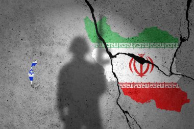 İsrail ve İran 'ın bayrakları çatlamış beton bir duvara asker gölgesi ile boyanmış.