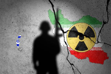 Kırık beton bir duvara asker gölgesi ve nükleer silah işareti ile İsrail ve İran 'ın bayrakları