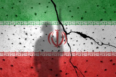 Protestocuların gölgesi altında beton bir duvara İran bayrağı