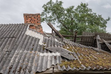 Asbest temizleme. Eski ve çok tehlikeli asbest çatı. Çevredeki asbest tozu.