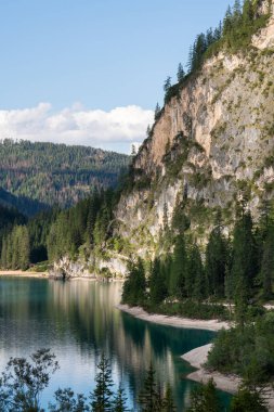 Dağ tepeleri. Taşlar. Vahşi yaşam. İtalya. Dolomitler. Alpler. Mavi gökyüzü. Dağlardaki mavi göl. Pragser wildsee. Logo Braies. Göl