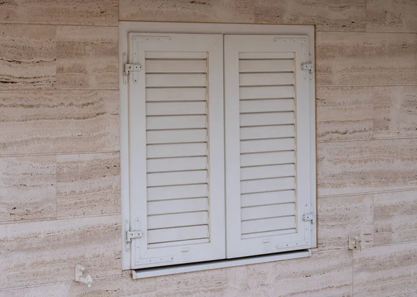 Window with white wooden shutters, White wooden blinds.