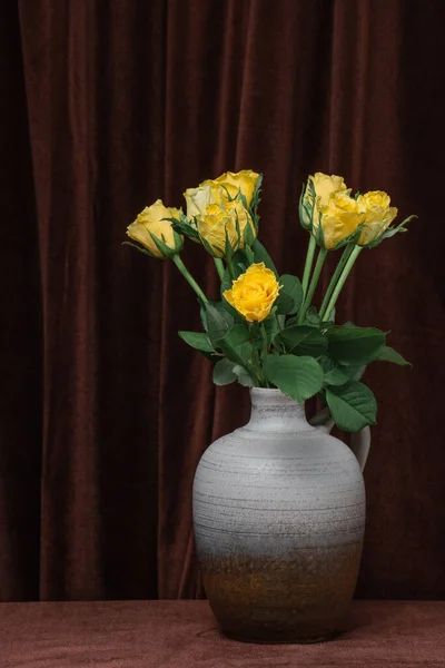濃い茶色の生地を背景に 灰色の花瓶に黄色のバラの花の美しい花束 テキスト コピースペースの場所 — ストック写真