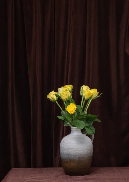 Koyu Kahverengi Kumaştan Yapılmış Gri Bir Vazoda Sarı Güllerden Oluşan — Stok fotoğraf