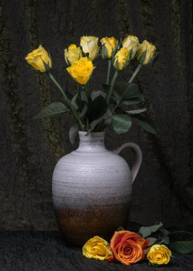 Vazoda bir buket sarı gül, sürahi. Koyu renk kumaş arka plan. Yakınlarda üç gül var. Yazı için uygun bir yer. çiçek durgun hayat