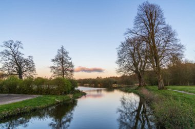 Gün batımında küçük bir nehri olan görkemli bir manzara. Gün batımında küçük turuncu bulut. 