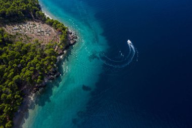 Zümrüt denizdeki turist teknesi kuş bakışı manzaralı, güzel kıyı şeridi kalın ağaçlarla kaplı. Hırvatistan 'ın Dalmaçya kentinde Makarska Riviera