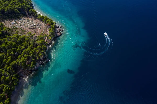 Zümrüt denizdeki turist teknesi kuş bakışı manzaralı, güzel kıyı şeridi kalın ağaçlarla kaplı. Hırvatistan 'ın Dalmaçya kentinde Makarska Riviera