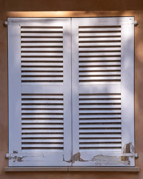 Window with white wooden shutters, white wooden blinds