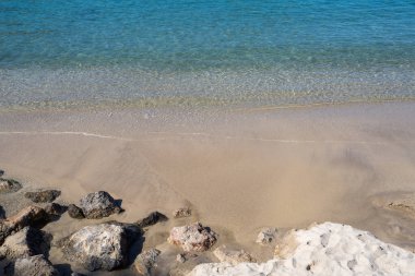 Mavi deniz, kumlu sahil, ön planda büyük taşlar. Zevk, rahatlama. Mallorca, İspanya 
