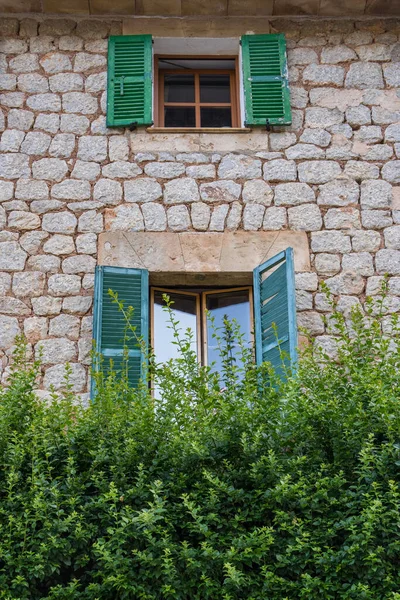 stone wall in a house with a window, green wooden shutters. Port de Soller, Mallorca, Mediterranean Sea, Spain
