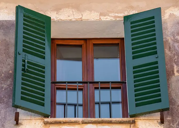 Brown window with green shutters