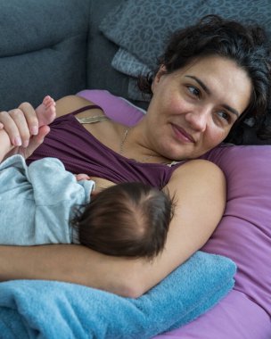 Sevgi dolu bir anne yeni doğan bebeğine bakar. Annem yeni doğmuş bebeğini emziriyor. Emzirme..