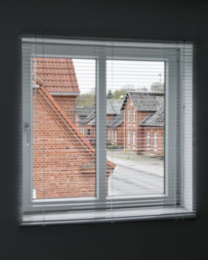 İç mekan. Pencereden sokağa ve kırmızı tuğladan evlere bak.