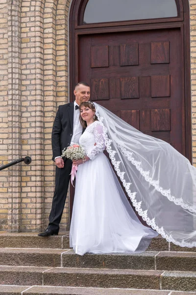 Bugün, birlikte geçirdiğimiz pek çok harika günün ilki. Gelin ve damat merdivenlerde duruyorlar. Gelinin fotoğrafı çıkıyor.