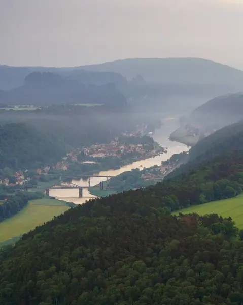 Aerial view of Bad Schandau in Saxon Switzerland in the early foggy morning, Carolabruecke bridge on the Elbe river, sandstone rocks and mountains