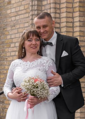 Gelin ve damat evlendikten sonra basamaklarda dikiliyorlar. Damat usulca eğildi gelini öpmek için.