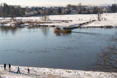 Kışın Dresden şehri ve Elbe Nehri manzarası. Feribot, karşıya geçiyor. Ünlü turistik yer.