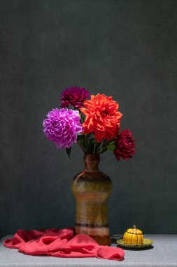Çiçeklerle dolu bir hayat. Koyu gri arkaplanda koyu renkli bir vazoda pembe, kırmızı, sarı yıldız çiçekleri. Tex için yer