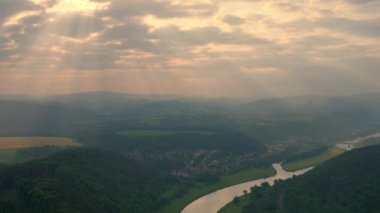 Sabah atmosferi. Doğan güneş ışınları. Kötü Schandau 'nun Saxon İsviçre' deki hava manzarası sisli bir sabahın erken saatlerinde Elbe nehri üzerindeki Carolabrcke köprüsü, kumtaşı kayalıkları ve dağlar..